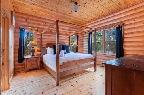 a bedroom with a bed in a log cabin at Le Cerf 53 Fiddler Lake in Mille-Isles