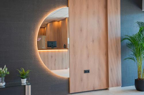 a hallway with a circular mirror on the wall at Hotel Caravaca Resort in Caravaca de la Cruz
