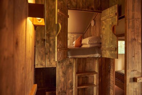 グラストンベリーにあるBramley Lodgeの木造キャビン内の二段ベッド付きのベッドルーム1室を利用します。