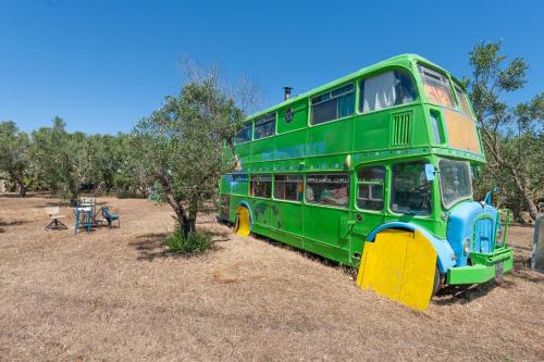 a green double decker bus parked in a field at Sprocketlandia in Frigole