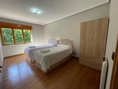a bedroom with two beds and a wooden floor at Dacarreda in Villamayor