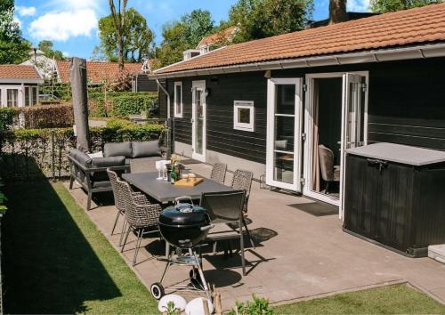 a patio with a grill and a table and chairs at Beachhouse Strandglück nur ca 100m bis zum Strand in Hulshorst