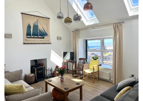 a living room with a sailboat on the wall at House By The Sea in Portsoy