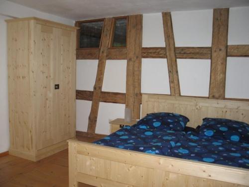 Schlafzimmer mit einem Holzbett mit blauer Bettwäsche in der Unterkunft Natur Idylle mit Tieren in der Dachsmühle zwischen Bodensee und Schwarzwald in Immendingen