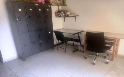 a room with a desk and two chairs and a table at Yellow House Hostel in Medellín