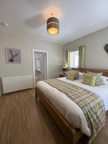 a bedroom with a large bed in a room at Drumlinn Cottage in Bridge of Cally
