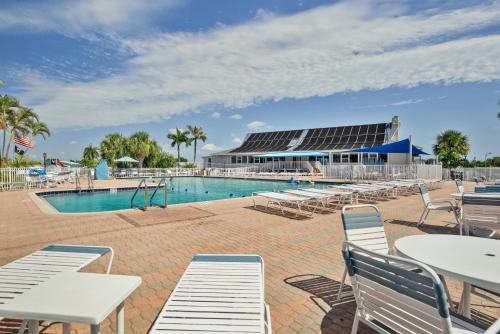 a pool with tables and chairs and a building at Nettles Island 1383 in Jensen Beach