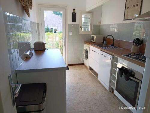 une cuisine avec un évier et un plan de travail dans l'établissement Maison pittoresque à Argelès-sur-Mer avec jardin clôturé, à Argelès-sur-Mer