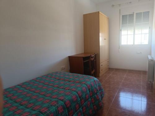a bedroom with a bed and a cabinet and a window at Casa Braila in Campo Arcís