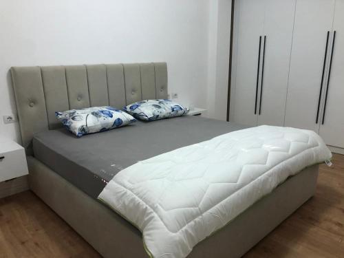 a bed with two pillows on it in a bedroom at Stylish Room by Canyons & City in Çorovodë