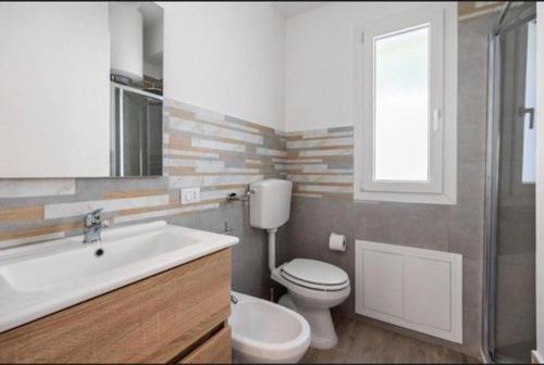 a bathroom with a toilet and a sink and a mirror at la villetta sul mare in Palermo