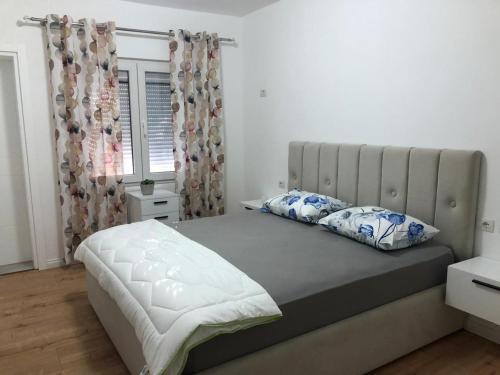 a bedroom with a large bed with two pillows at Stylish Room by Canyons & City in Çorovodë