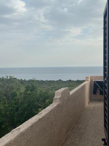 a stone wall with a view of the ocean at Mani Spot Nezoulas in Álika