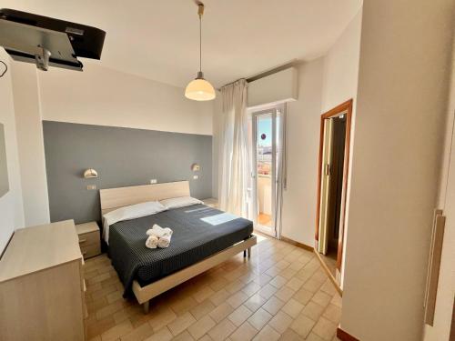 Un dormitorio con una cama con un osito de peluche encima. en Hotel Atlas, en Gabicce Mare