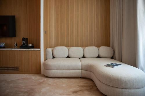 a living room with a white couch in a room at Domaine de Verchant & Spa - Relais & Châteaux in Montpellier