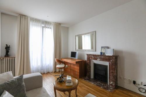 un salon avec une cheminée et un canapé dans l'établissement Bright apartment for 4 with balcony, à Paris