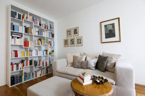 un salon avec un canapé et une étagère dans l'établissement Bright apartment for 4 with balcony, à Paris