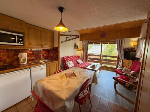 une cuisine avec une table et des chaises dans une cuisine dans l'établissement Appartement cosy 2 pièces + mezzanine, balcon, animaux tolérés - FR-1-293-116, aux Saisies