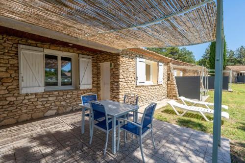 une table et des chaises sur le patio d'une maison dans l'établissement Small stone house in quiet residence, à La Roque-sur-Pernes