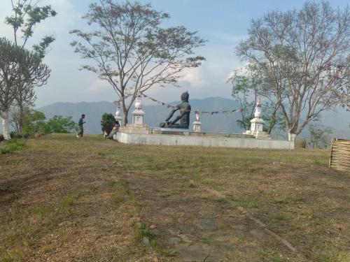 a statue of a man sitting on a ledge in a park at Lopchan Homesstay in Darjeeling