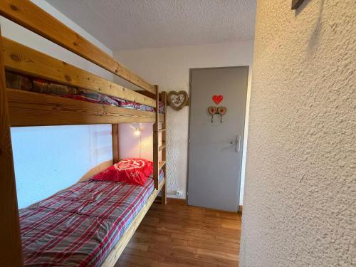 - une chambre avec des lits superposés et une couette rouge dans l'établissement Les Saisies - 2 pièces cabine pour 5 pers, animaux tolérés, tout équipé - FR-1-293-119, aux Saisies