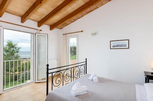a bedroom with a bed and a balcony at YourHouse Escull in Colonia de Sant Pere