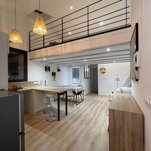 une cuisine et un salon avec une table et des chaises dans l'établissement Le Vox Appart', à Montélimar