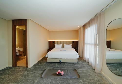 a hotel room with a bed and a mirror at Citadines Almaz Aparthotel Casablanca in Casablanca