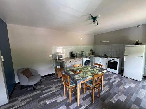 une cuisine avec une table, des chaises et un réfrigérateur dans l'établissement Le Gîte du Chat Gru, à Saulxures-sur-Moselotte