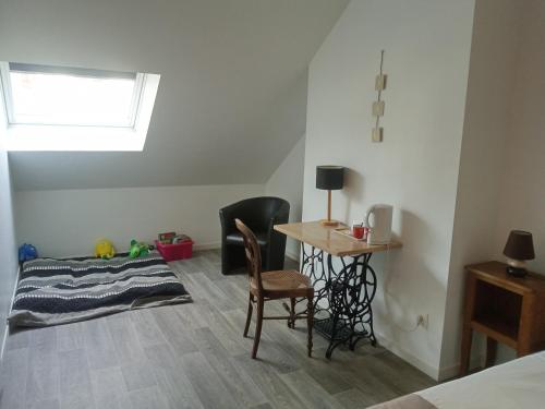 a bedroom with a desk and a table and chairs at Les Charmilles in Saint-Jean-de-Losne