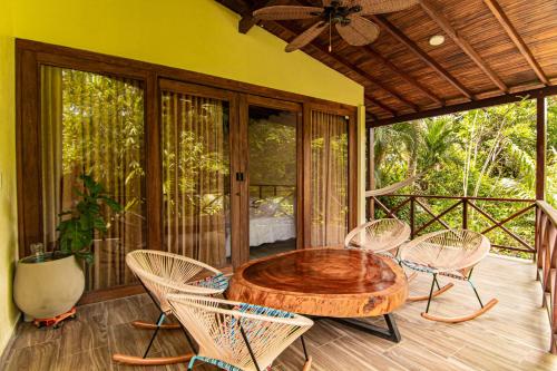 a wooden table and chairs on a porch at Portales del Tayrona Garden Hotel in Calabazo
