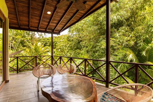 a patio with three chairs and a table on a deck at Portales del Tayrona Garden Hotel in Calabazo