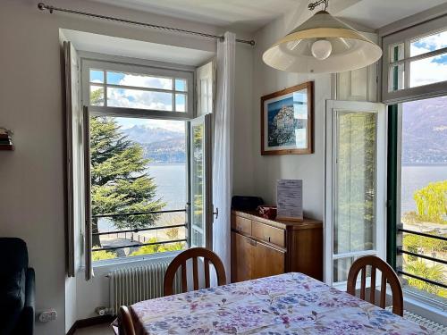 a dining room with a table and two large windows at Casa Mary Varenna in Varenna