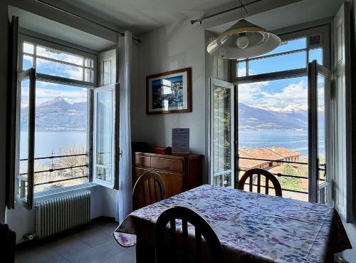 a dining room with a table and two large windows at Casa Mary Varenna in Varenna
