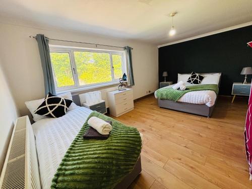 a bedroom with two beds and a window at Welbeck House, close to Swansea Central in Cockett