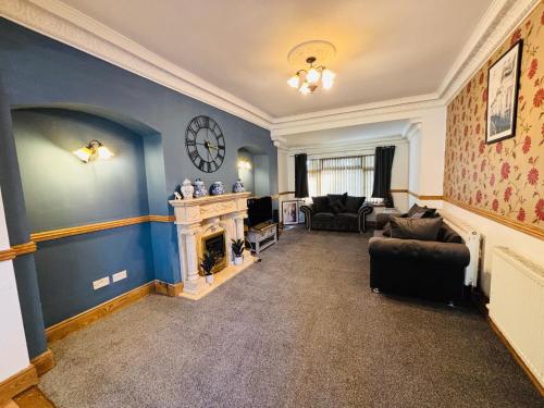 a living room with a fireplace and a clock on the wall at Welbeck House, close to Swansea Central in Cockett