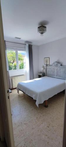 un grand lit blanc dans une chambre avec une fenêtre dans l'établissement Maison pittoresque à Argelès-sur-Mer avec jardin clôturé, à Argelès-sur-Mer