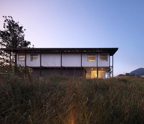 a house sitting on top of a grassy hill at The Lone Pine - Architect's Villa for adventure & retreat in Payingomuwa