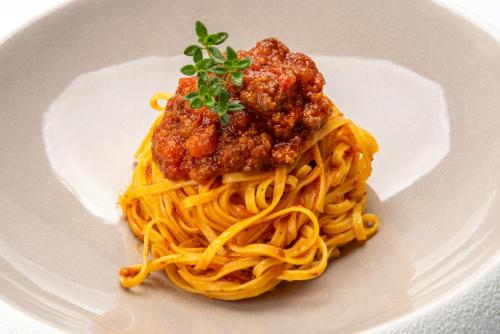 a plate of spaghetti with meatballs on top at Il Boscareto Resort & Spa in Serralunga d'Alba