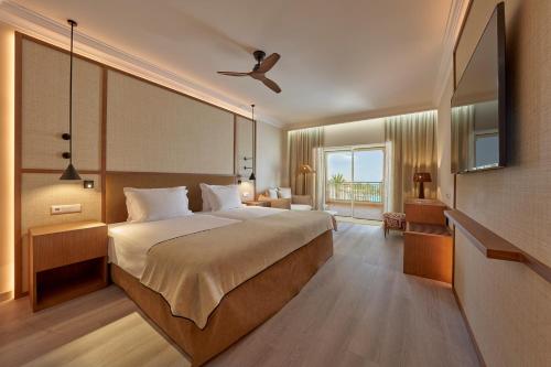 a bedroom with a large bed with a ceiling fan at PortoBay Blue Ocean in Albufeira