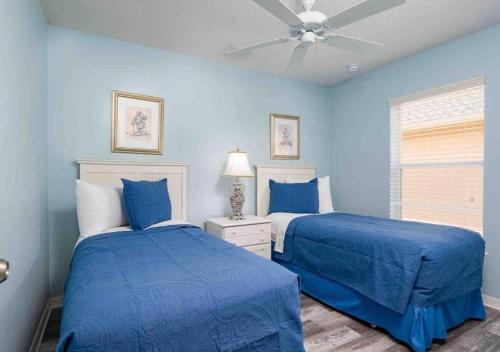 ein blaues Schlafzimmer mit 2 Betten und einem Deckenventilator in der Unterkunft 5 bedroom, 7 bed , 3 bathroom Midterm Rental Home with Pool and Game room, near Disney in Davenport