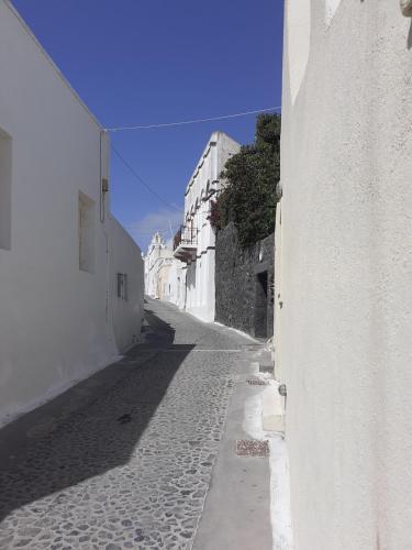an alley with white buildings and a blue sky at Panoramic view apartment in Megalokhori