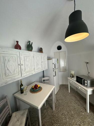 a kitchen with a table with a plate of fruit on it at Panoramic view apartment in Megalokhori