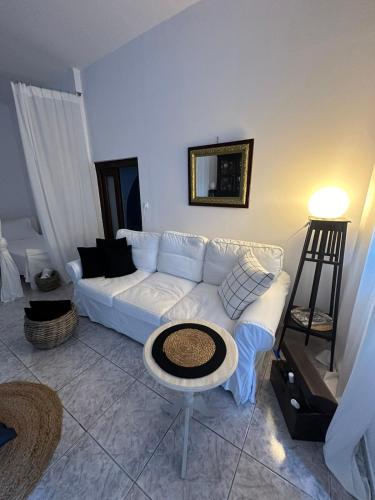 a living room with a white couch and a table at Panoramic view apartment in Megalokhori