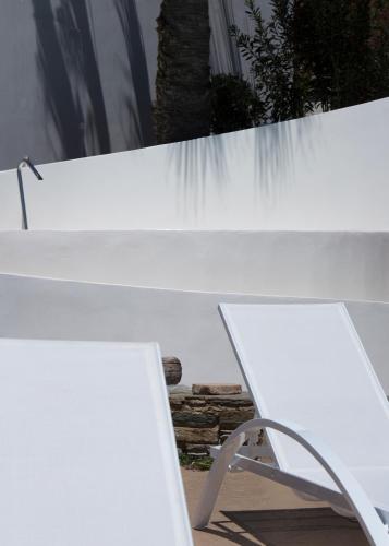 a white bench sitting in front of a waterfall at Byzantio Beach Suites & Wellness in Agios Sostis