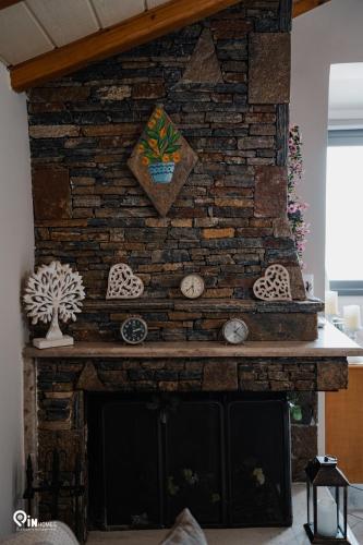 a brick fireplace with clocks on it at 'Four 4Season' With Amazing View in Vraná