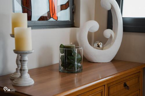 a candle and a vase on a dresser with a mirror at 'Four 4Season' With Amazing View in Vraná