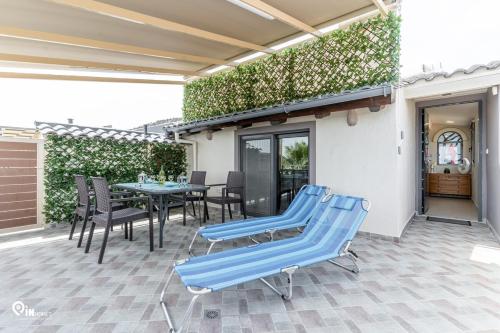 a patio with blue chairs and a table at 'Four 4Season' With Amazing View in Vraná