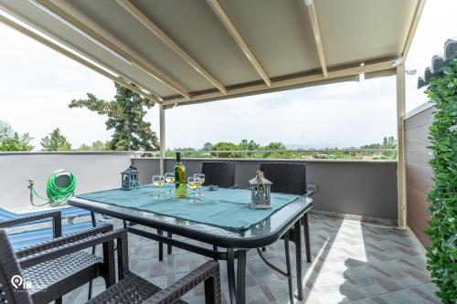 a patio with a table with wine glasses on it at 'Four 4Season' With Amazing View in Vraná