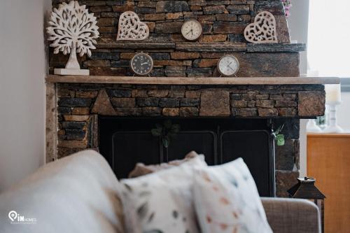 a living room with a fireplace with clocks on it at 'Four 4Season' With Amazing View in Vraná